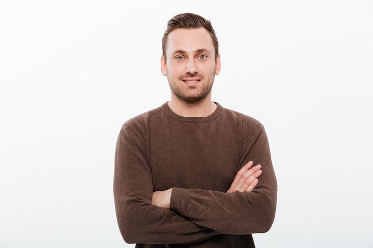 Gratis Foto knappe jonge vrolijke man met gekruiste armen