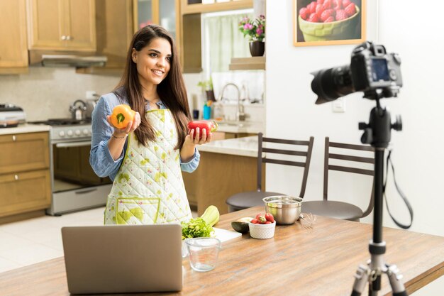 Knappe jonge vrouwelijke foodblogger die kooktips geeft op video