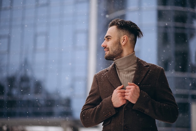 Knappe jonge zakenman buiten in de winter