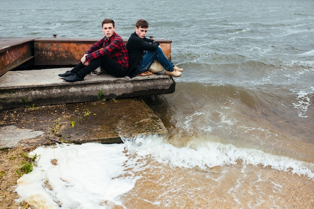 Knappe jongens poseren op de pier