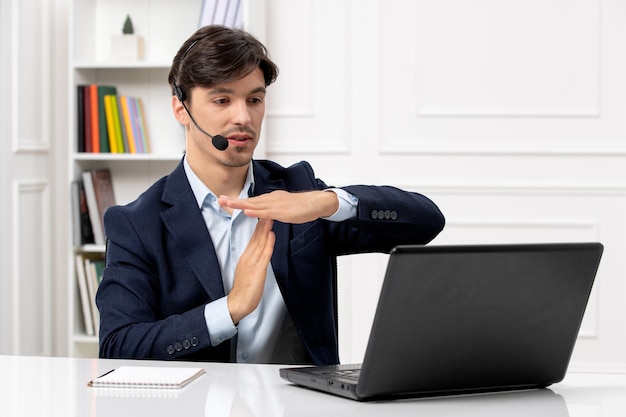 Knappe kerel van de klantenservice met headset en laptop in pak met stopbord