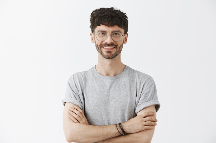 Gratis Foto knappe knappe jongen poseren tegen de witte muur