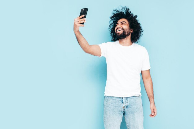 Knappe lachende hipster man poseren in studio