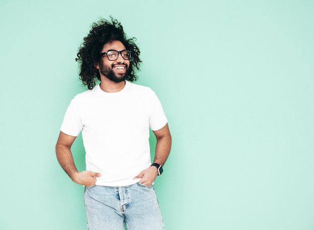 Knappe lachende hipster man poseren in studio