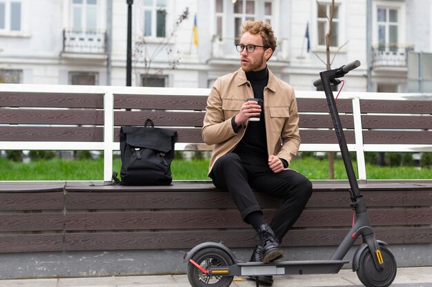 Knappe man buiten genieten van een kopje koffie