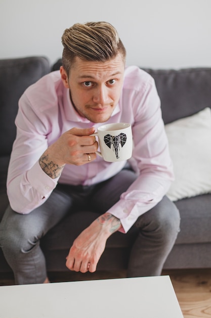 Gratis foto knappe man die een kopje koffie houdt