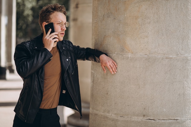 Knappe man in bril met behulp van de telefoon