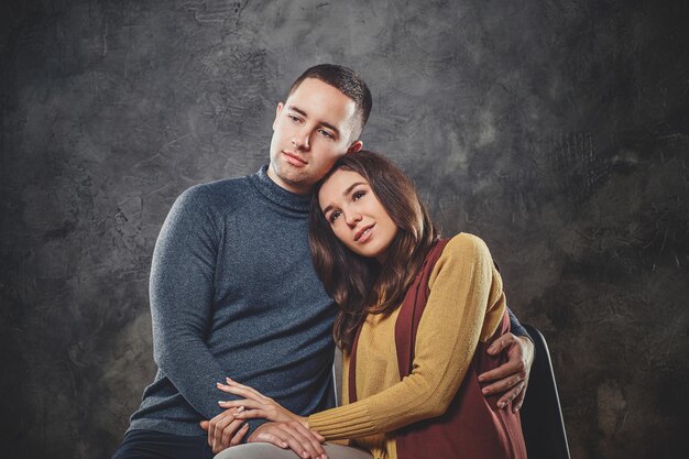 Knappe man knuffelt zijn aantrekkelijke gelukkige vrouw in de fotostudio.