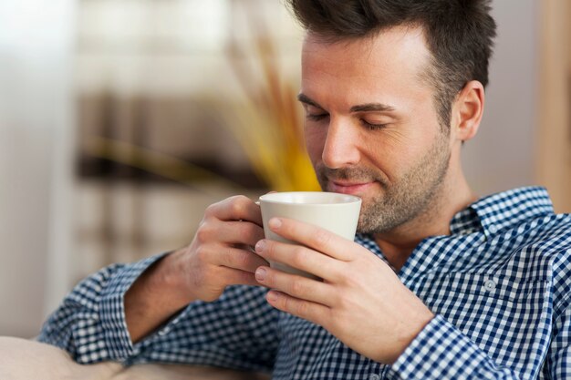 Knappe man koffie in de ochtend proeven