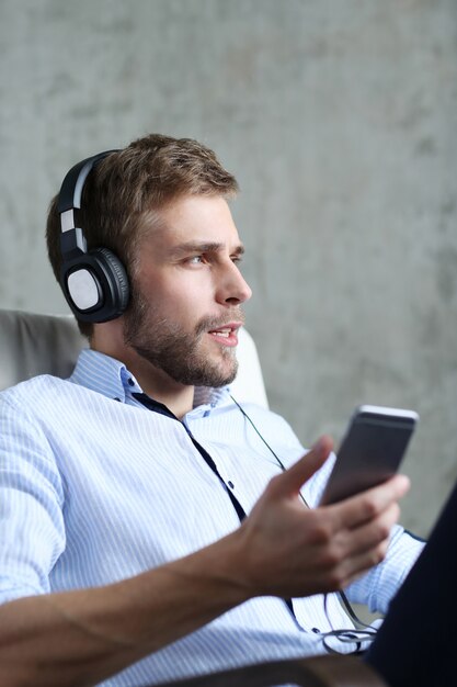 Knappe man luisteren muziek op koptelefoon