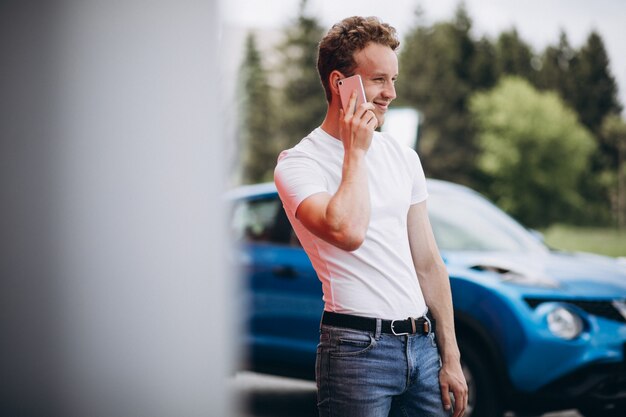 Knappe man met behulp van de telefoon door de auto