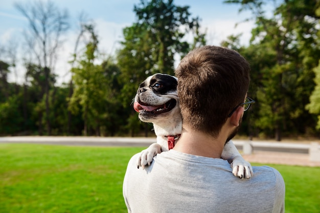 Knappe man met franse bulldog, wandelen in het park