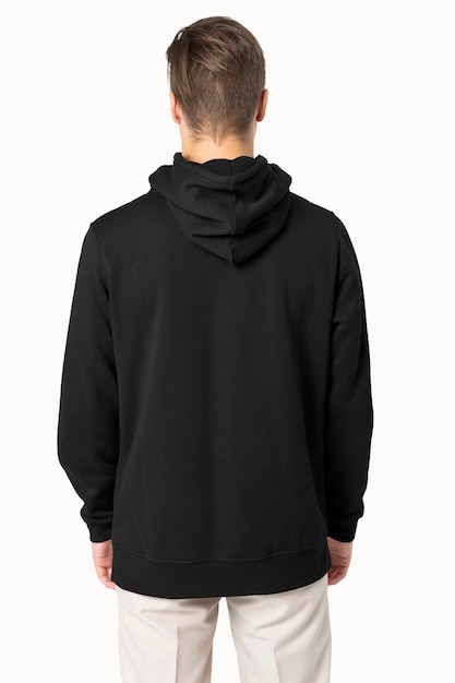 Gratis foto knappe man met zwarte hoodie voor achteraanzicht van de wintermode
