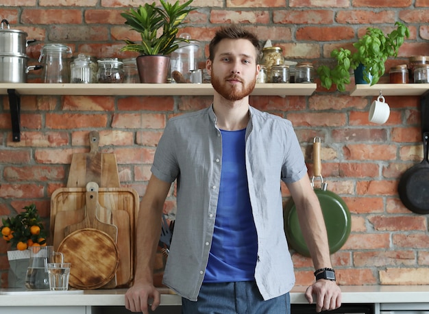 Knappe man poseren in de keuken