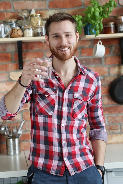 Knappe man poseren in de keuken