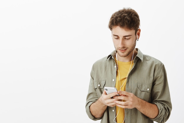 Knappe man poseren met smartphone in de studio