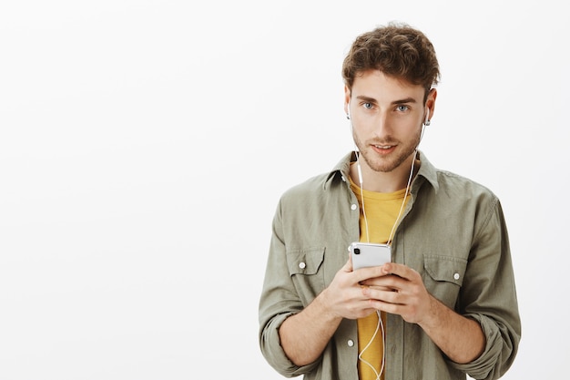 Knappe man poseren met smartphone in de studio