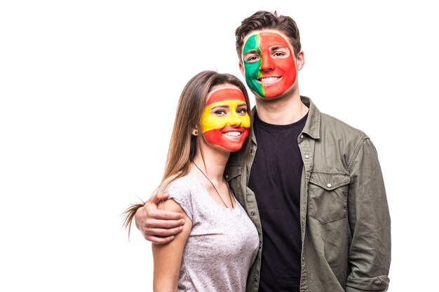 Knappe man supporter fan van Portugal nationale team geschilderde vlag gezicht knuffel vrouw supporter fan van Spanje nationale team. Fans van emoties.
