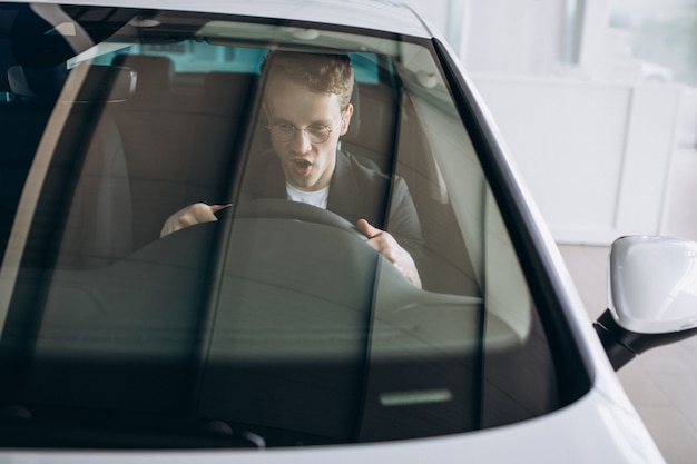 Gratis foto knappe man zit in een auto