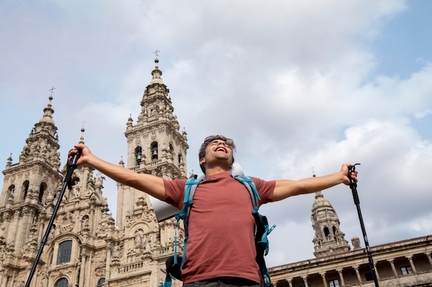 Gratis foto knappe mannelijke reiziger bij een historische kathedraal