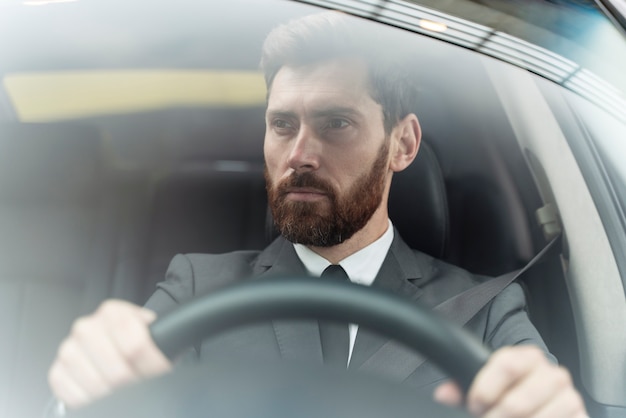 Knappe mannelijke taxichauffeur in kostuum