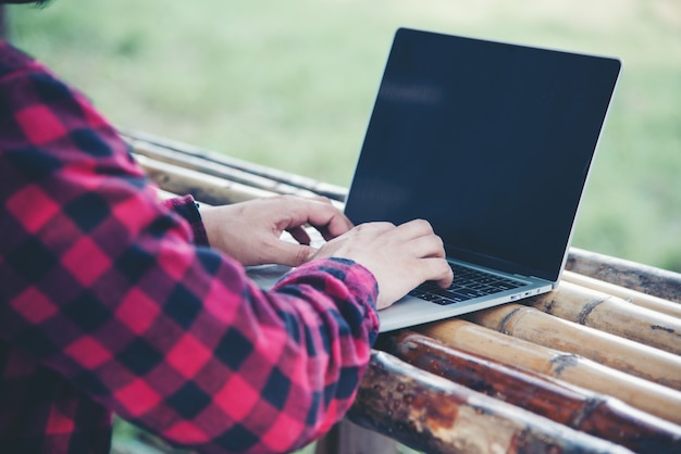 Gratis foto knappe mens die laptop in de reisaard met behulp van