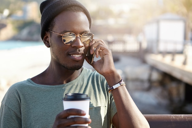 Knappe modieuze hipster met leuk telefoongesprek
