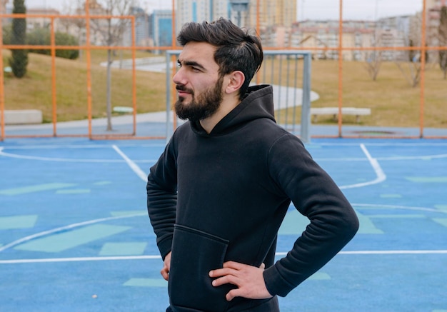 Knappe sportman staat op voetbalveld en denkt Foto van hoge kwaliteit