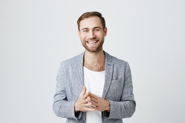 Knappe succesvolle zakenman die handen en het glimlachen wrijft