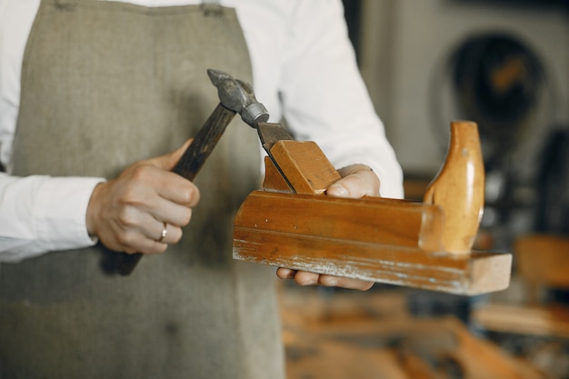 Gratis foto knappe timmerman die met een hout werkt