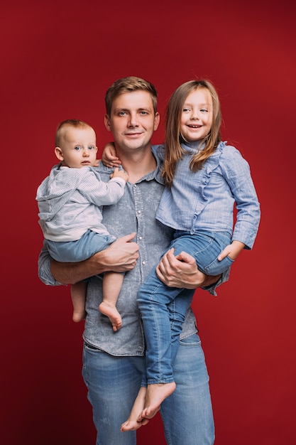 Knappe vader houdt twee van zijn kinderen op zijn handen