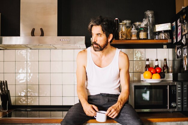 Knappe volwassen man dromen in de keuken