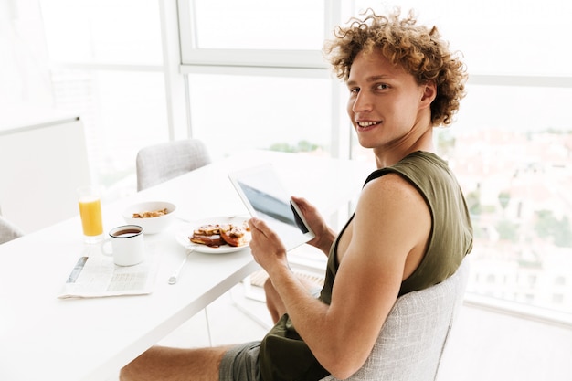 Knappe vrolijke man met behulp van tablet pc