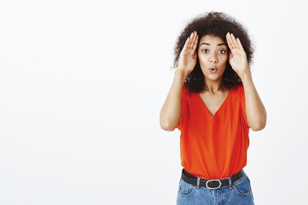 Knappe vrouw met afro kapsel poseren in de studio