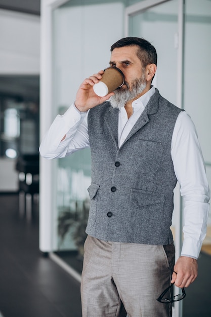 Knappe zakenman die koffie drinkt op kantoor