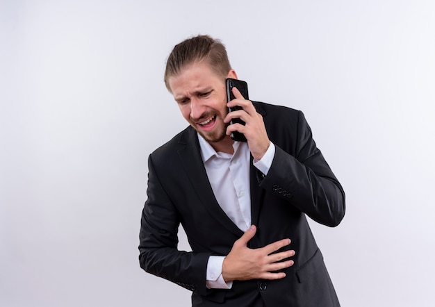 Knappe zakenman dragen pak praten op mobiele telefoon teleurgesteld staande op witte achtergrond