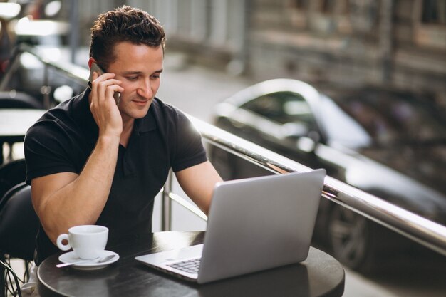 Knappe zakenman in een café met laptop