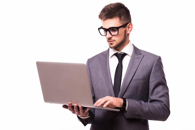 Knappe zakenman met laptop die op witte achtergrond wordt geïsoleerd