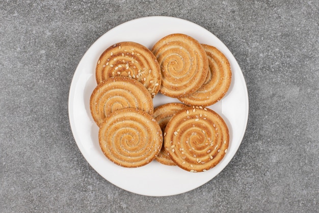 Knapperige koekjes met zaden op witte plaat.