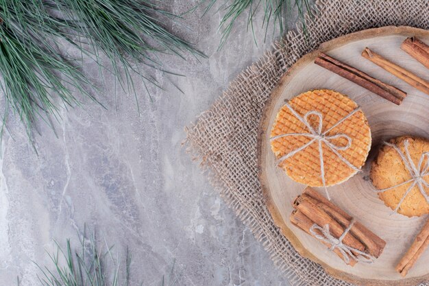 Knapperige koekjes op een houten bord met rond kaneelstokjes