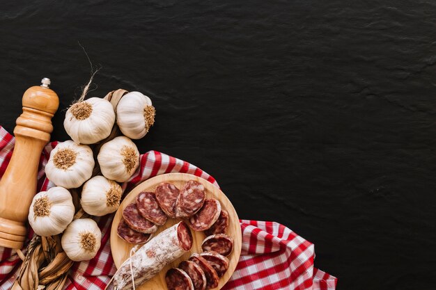 Knoflook en worsten dichtbij kruiden op servet