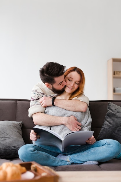 Gratis foto knuffelend paar dat een boek bekijkt