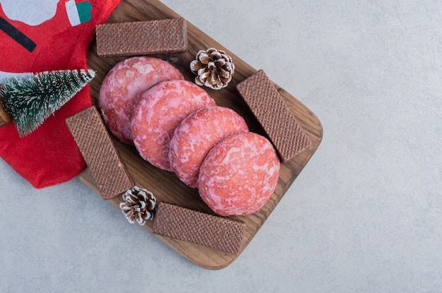 Koekjes, chocoladewafels en kerstversieringen op marmeren oppervlak