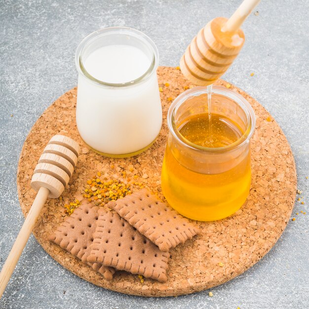 Koekjes en bijenpollen met melk en honingpotten kurkachtbaan
