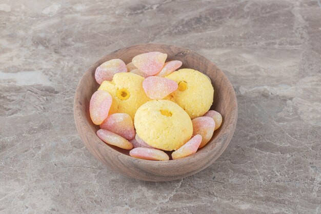 Koekjes en gelei-snoepjes gebundeld in een kleine kom op een marmeren oppervlak