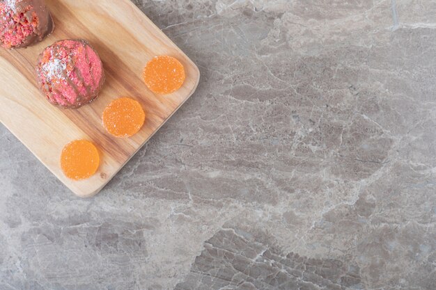 Koekjes en marmelades op een bord op marmeren oppervlak