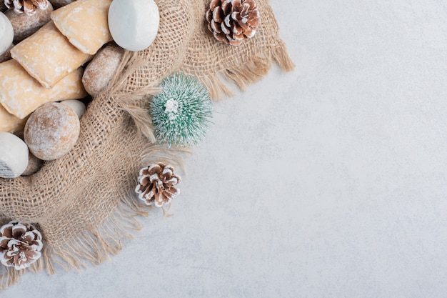 Koekjes gebundeld op een stuk stof te midden van kerstversieringen op een marmeren oppervlak