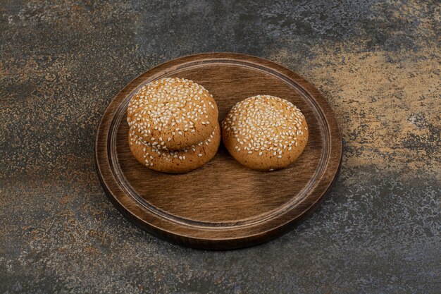 Koekjes met sesamzaadjes op een houten bord.