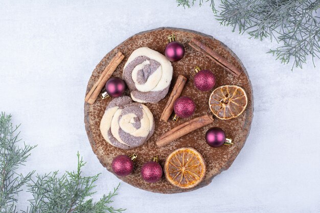 Koekjes met snuisterijen, kaneel en stukjes sinaasappel op houten stuk