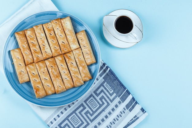 Koekjes op een bord en een koffiekopje op blauwe achtergrond